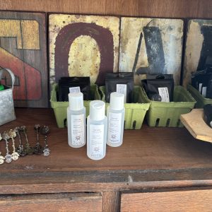 A rustic shelf with skincare products and decorative items.