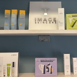 Shelf displaying skincare and beauty products in minimalist packaging.