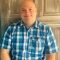 Smiling man in blue plaid shirt
